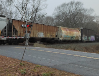 Two covered hoppers, a boxcar, and a tank car move through the crossing at Packerville, CT