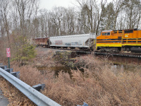 A Providence and Worcester Dash-8 locomotive and an America's Styrenics covered hopper cross the Merrick Brook Bridge