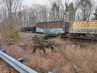 A CN cylindrical covered hopper, an Iowa Northern Rwy Boxcar, and a General American Marks Co tank car cross the Merrick Brook Bridge in Scotland, CT